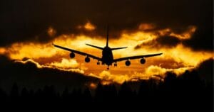silueta de avión en el cielo sobre un atardecer
