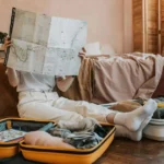 maletas abiertas, empacando ropa y mirando un mapa