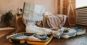 maletas abiertas, empacando ropa y mirando un mapa