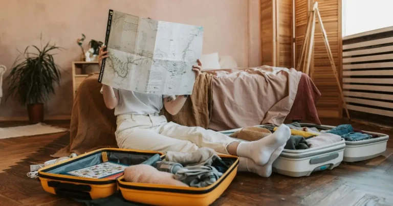 maletas abiertas, empacando ropa y mirando un mapa