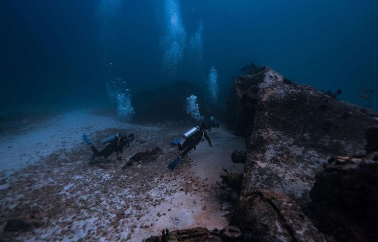 Buzos explorando un barco hundido en las aguas cristalinas de Isla Mujeres, México.