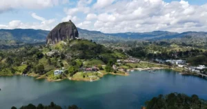 Vista panorámica del embalse de Guatapé desde el frente de la Piedra del Peñol, con islas verdes y agua turquesa al fondo.